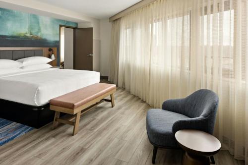 a hotel room with a bed and a chair at Oshkosh Marriott Waterfront Hotel & Convention Center in Oshkosh