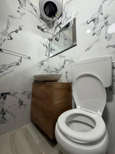 a bathroom with a white toilet and a sink at ORA Appartment's in Shkodër