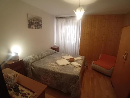 a small bedroom with a bed and a chair at Al Sole Apartment in Locca