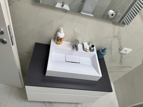a bathroom with a white sink and a mirror at Casa Narciso, semi-detached cottage in Marina di Massa
