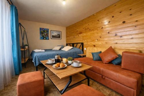 a room with a bed and a couch and a table at TEVRA Nature, Retreat Mountain Cabins Above the City Ijevan, Dilijan in Ijevan