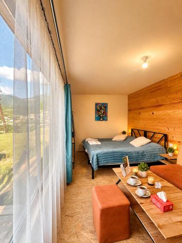 a bedroom with a bed and a table in a room at TEVRA Nature, Retreat Mountain Cabins Above the City Ijevan, Dilijan in Ijevan
