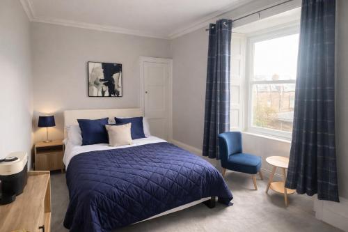 a bedroom with a bed and a chair and a window at Station Hotel in Burghead