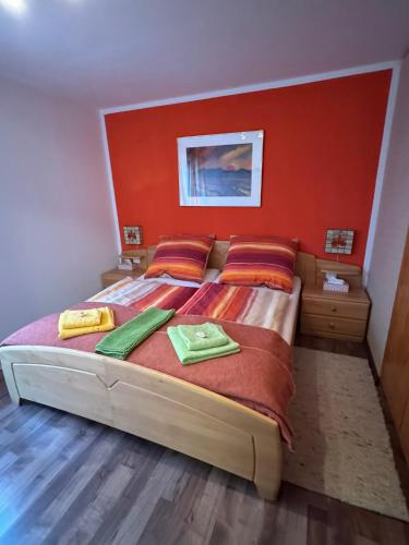 a bedroom with a large bed with an orange wall at Ferienwohnung Sunnabichi in Wertach