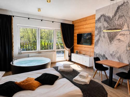a bedroom with a tub and a bed at Aparthotel Diamond SPA Relax in Białka Tatrzańska