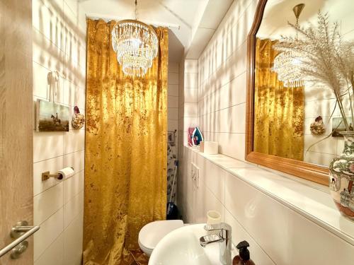 a bathroom with a gold shower curtain and a sink at 2 Unique Apartments in the Historic Center in Straubing