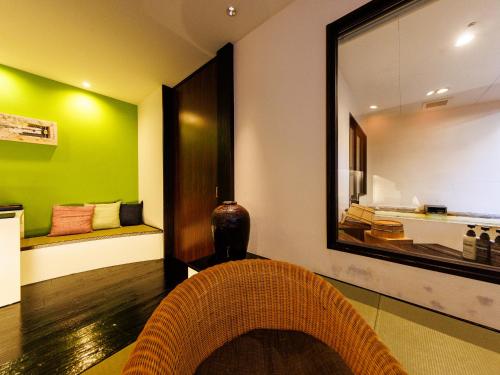 a living room with a mirror and a chair at Yamayuri no Yado in Hanamaki