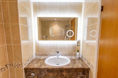 a bathroom with a sink and a mirror at Marwell Hotel Winchester South in Winchester