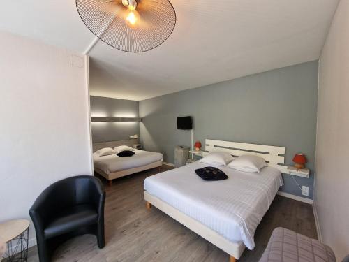 a hotel room with two beds and a chair at Come Inn in Neufchâtel-en-Bray