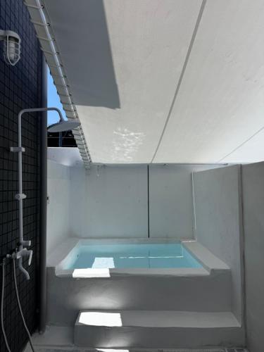 a bath tub in a bathroom with a shower at VILLA TSUKUNAMI aoshima in Miyazaki