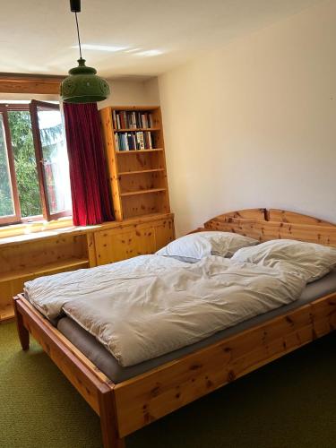 a bedroom with a wooden bed in front of a window at Mountainview Flattnitz in Flattnitz
