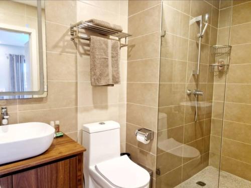 a bathroom with a shower and a toilet and a sink at Petit Charlie @ Forest view in Banjul