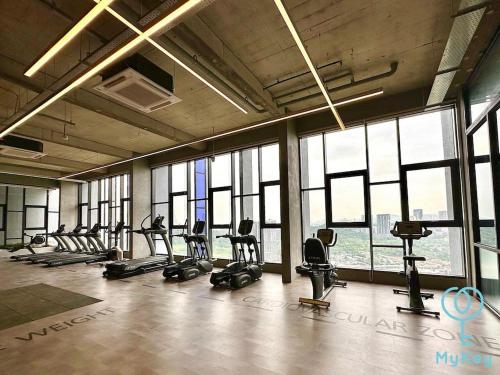 a gym with rows of exercise equipment in a room with windows at Miller Cozy Home in Kuala Lumpur