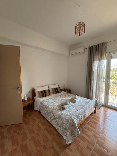 a bedroom with a bed and a large window at Margaret's Guest House in Mesopotam