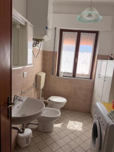 a bathroom with a white toilet and a sink at Casa di Mary in Pontremoli