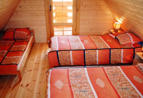 a bedroom with three beds in a cabin at Domki Maks in Bobolin