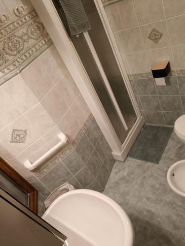a bathroom with a white toilet and two sinks at Centro - La Tana di Nico & Chri in Bardonecchia