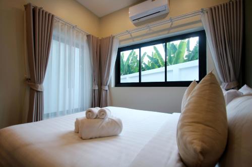 a bedroom with a bed with two towels on it at Sunset Pool Villa Ao Nang Krabi in Ao Nang Beach