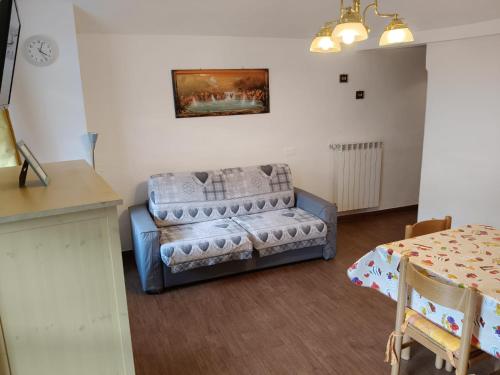 a living room with a couch and a table at Centro - La Tana di Nico & Chri in Bardonecchia