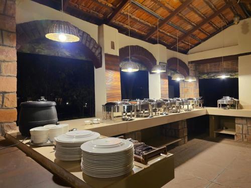 a large kitchen with white plates on a table at Tiger Trails Resort in Tāla