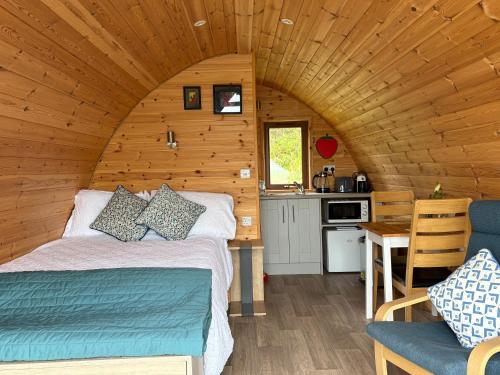 a bedroom with a bed in a wooden cabin at Kingsford Pod in Wexford