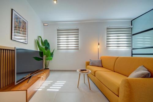 a living room with a couch and a tv at The Oasis - R4 in Senglea
