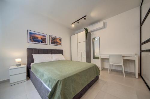 a bedroom with a bed and a desk in it at The Oasis - R4 in Senglea