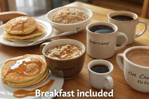 a table with plates of pancakes and cups of coffee at Soho House - 20 Min to NYC - Breakfast Included- A in Jersey City