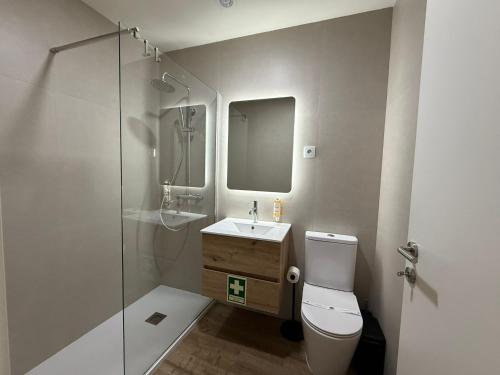 a bathroom with a toilet and a sink and a shower at O Vilarealense Heritage Apartment in Vila Real