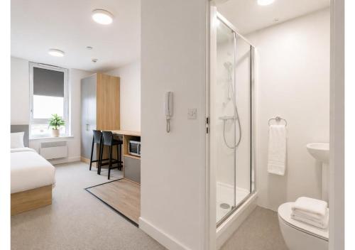 a white bathroom with a shower and a toilet at Globeworks by UTDM in Birmingham