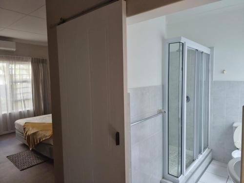 a bathroom with a toilet and a glass shower at Blue Bend Valley in East London