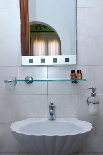 a white sink in a bathroom with a mirror at Onar Studios in Koufonisia