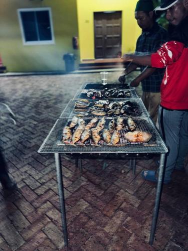 a grill with many different types of food on it at CD Garden Cottage in Kota Bharu
