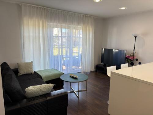 a living room with a couch and a tv at Pärnu Lubja Apartments in Pärnu
