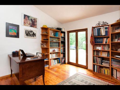 an office with a desk and book shelves with books at B&B da Odila in Poggio Nativo
