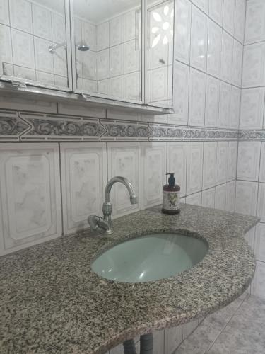 a bathroom counter with a sink with a faucet at Simplicidade e localização privilegiada no coração de Adrianópolis em Manaus in Manaus