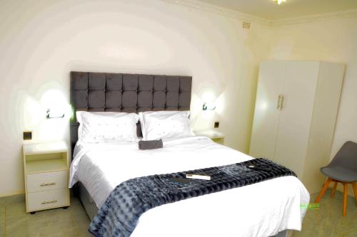 a bedroom with a large bed with a black headboard at On Edward in Bulawayo
