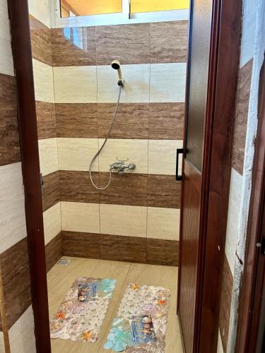 a shower in a bathroom with a wooden wall at Shalom Villa 2 in Vacoas