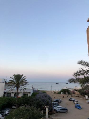 a view of the ocean from a parking lot at Hostal Alocs in Es Figueral Beach