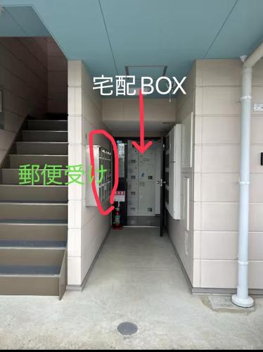 a building with a red box in front of a door at 東尋坊近く自転車無料 コンビニ目の前1ルーム貸切 in Mikuni