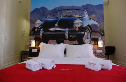 a bedroom with a bed with a car on the wall at Republica Vintage House in Viana do Castelo