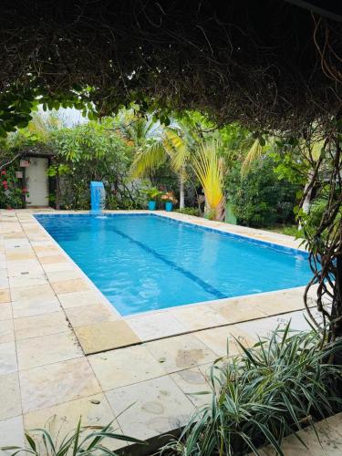 a large blue swimming pool in a yard at Casa Flamboyant Parajuru in Beberibe