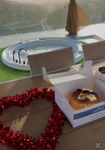a cake in a box on a table with a wreath at Grape Resort منتجع وشاليهات عنب in Ajloun