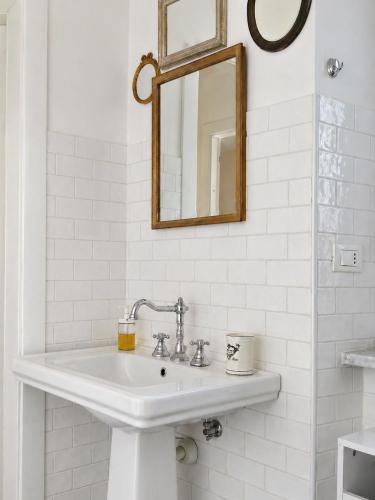a white bathroom with a sink and a mirror at Royal Nest Venaria Reale in Venaria Reale