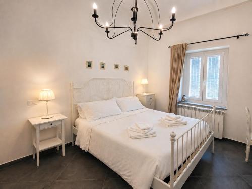 a bedroom with a white bed and a chandelier at Royal Nest Venaria Reale in Venaria Reale