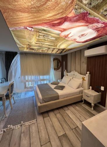 ein Schlafzimmer mit einem Bett und einem Gemälde an der Decke in der Unterkunft Apera garden in Bulgurca