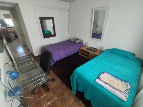 a bedroom with two beds and a glass table at Habitación Doble en Dpto compartido in Santiago