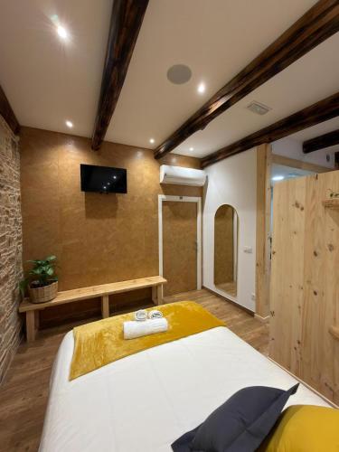 a bedroom with a bed and a flat screen tv at A Taberniña in O Pedrouzo
