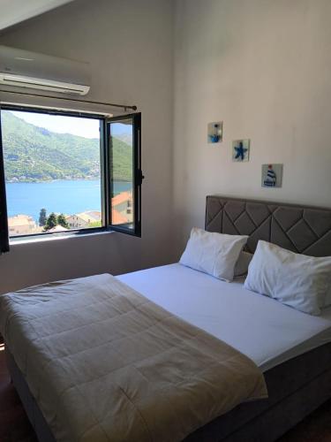 a bedroom with a large bed with a large window at Apart Capital FISA Kamenari in Kamenari