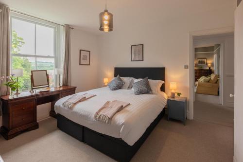 a bedroom with a bed and a desk and a window at The Clarence in Bishop Auckland